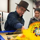 Group of people in a workshop setting engaging in an activity, the words "Celebrating" with a colorful "35 Years of Community" graphic overlay. 